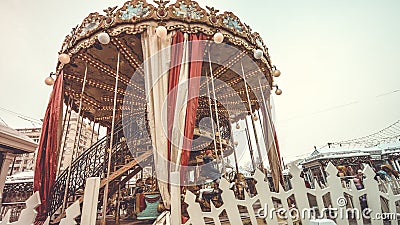 Children`s Carousel at an amusement park in the evening and night illumination. amusement park at night. Outdoor vintage colorful Editorial Stock Photo