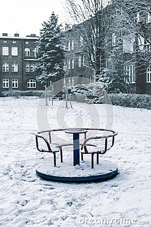 children's carousel covered with snow on the playground in winter Stock Photo