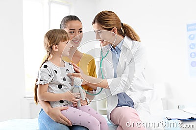 Children`s doctor examining little girl near parent Stock Photo