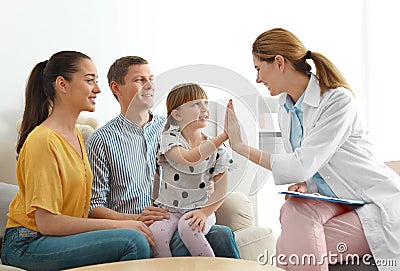 Children`s doctor visiting little girl with parents at home. Stock Photo