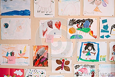 Children`s drawings on the wall in the room Stock Photo