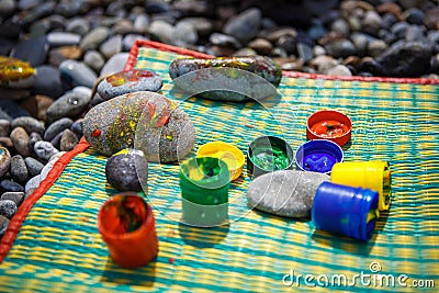 Children`s entertainment on a pebble beach-paint stones. Stock Photo