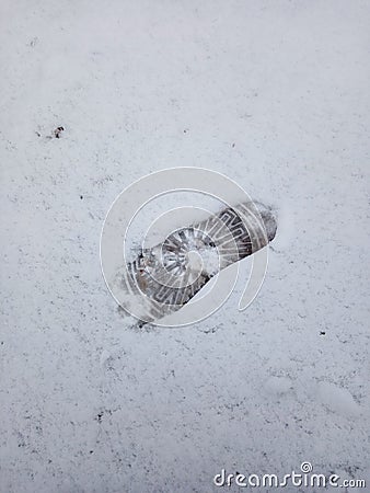 Children`s footprint from a boot on white snow in the winter season. Stock Photo