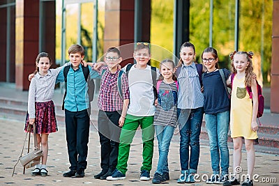 Children`s friendship. Schoolmate students stand in an embrace on the schoolyard. Stock Photo