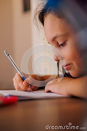 Children's hand close-up. the child uses a pencil to practice writing letters. The child learns to write in a notebook Stock Photo