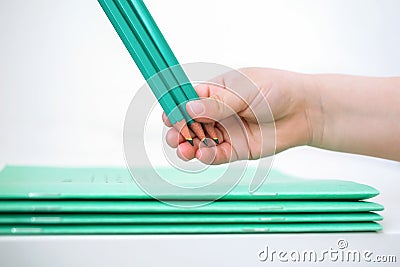 Children`s hand holds pencils near the school notebook Stock Photo