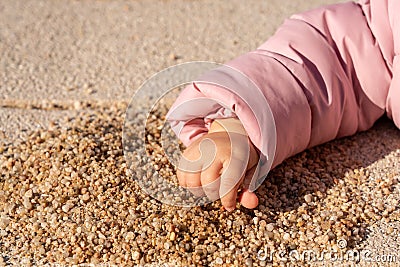 Children`s hand takes a handful of sand Stock Photo