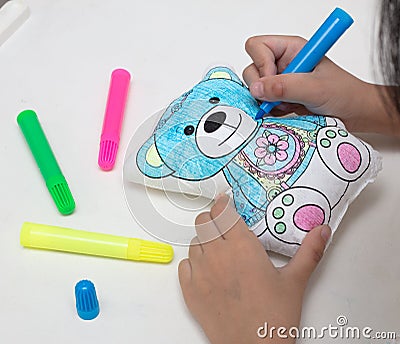 Children`s hands coloring toy bear with watercolor pens Stock Photo
