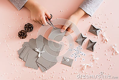 Children`s hands cut out blanks for making an advent calendar on a table in Christmas decorations Stock Photo