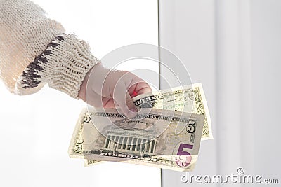 Children's hands in a sweater hold small dollar bills Stock Photo