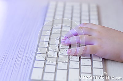 Children& x27;s hands are typing on the keyboard. The child plays computer games. Stock Photo