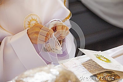 children's hands untie the bag, which contains the rosary for the first communion. Stock Photo