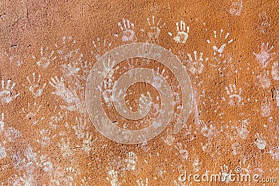 Multiple colorful children hand prints on huskily brown wall Stock Photo