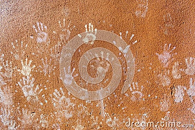 Multiple colorful children hand prints on huskily brown wall Stock Photo