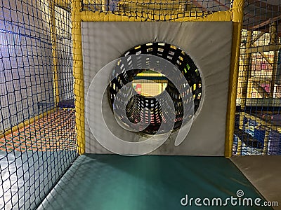 Children's rope fabric tunnel taken a a soft play area Stock Photo