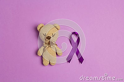 Children`s toy with a Purple epilepsy awareness ribbon on a purple background. World epilepsy day Stock Photo