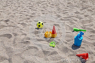 children's toys on the beach sand against turquoise sea Stock Photo