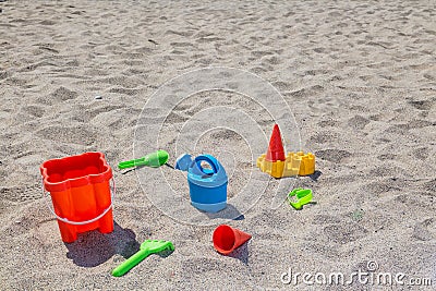 children's toys on the beach sand against turquoise sea Stock Photo