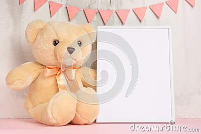 Children`s toys, a teddy bear and a frame on a light wall background, for design, layout. Baby shower Stock Photo