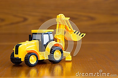 Children`s tractor yellow on a brown background Stock Photo