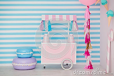 Children`s zone with sweets: lollipops, ice cream, macarons, balloon and candy bar. Children room with blue stripe Stock Photo