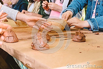 Children sculpt a figurine of a cat out of clay Stock Photo