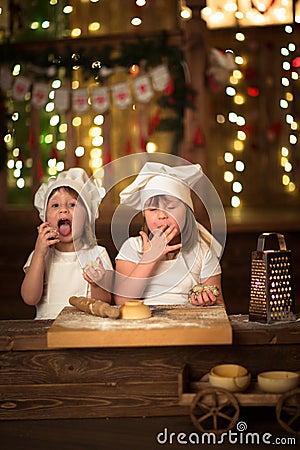 Children sisters cook with a rolling pin to stretch concept of Stock Photo