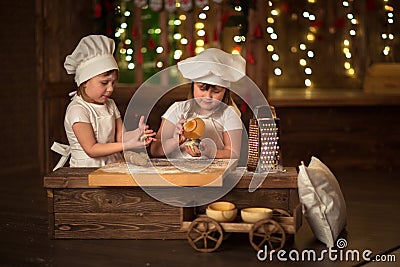 Children sisters cook with a rolling pin to stretch concept of Stock Photo