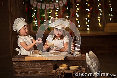 Children sisters cook with a rolling pin to stretch concept of Stock Photo