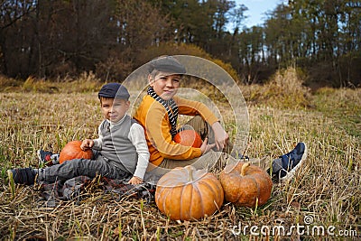 Children sit in a field with pumpkins. Healthy organic food. Stock Photo