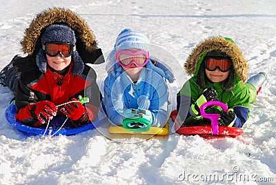 Children on sleds in snow Stock Photo