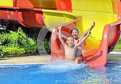 Children sliding down a water slide Stock Photo