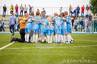 Children soccer football team with coach. Group of kids standing together on the pitch. Coach giving children`s soccer team instru Editorial Stock Photo