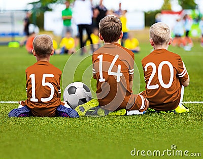 Children Soccer Team Playing Match. Football Game for Kids. Young Soccer Players Sitting on Pitch. Little Kids in Blue and Orange Editorial Stock Photo