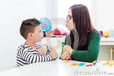 Children speech therapy concept. Preschooler practicing correct pronunciation with a female speech therapist. Stock Photo