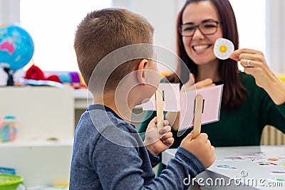 Children speech therapy concept. Preschooler practicing correct pronunciation with a female speech therapist. Stock Photo