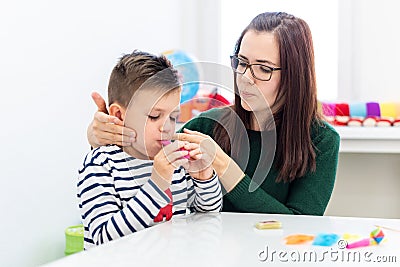 Children speech therapy concept. Preschooler practicing correct pronunciation with a female speech therapist. Stock Photo