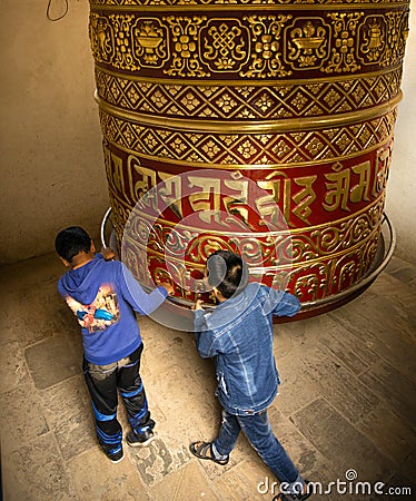 Children spinning prayer wheel Editorial Stock Photo