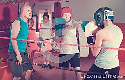 Children sportsmans at boxing workout with coach Stock Photo