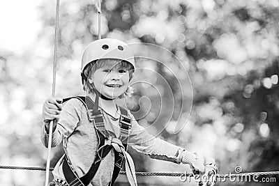 Children summer activities. Adventure climbing high wire park. Cute baby boy playing. Hiking in the rope park girl in Stock Photo