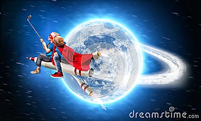 Children in superhero costumes fly in space on a rocket and shoot a selfie on a mobile phone. Stock Photo