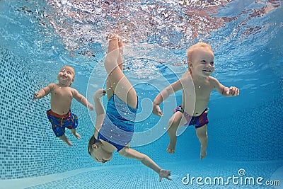 Children swim and dive underwater with fun in swimming pool Stock Photo