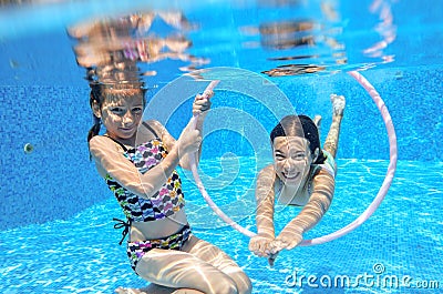 Children swim in pool underwater, happy active girls have fun under water, kids sport Stock Photo