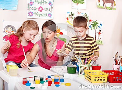 Children with teacher painting play room. Stock Photo