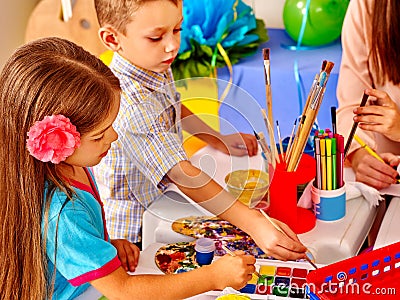 Children with teacher woman painting on paper in Stock Photo