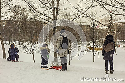 Children and their parents sledding in the winter in the snow Editorial Stock Photo