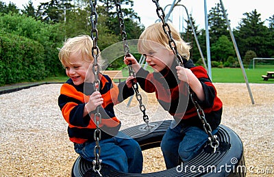 Children on Tire Swing Stock Photo