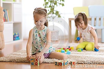 Children toddlers girls play toys at home, kindergarten or daycare centre. Stock Photo