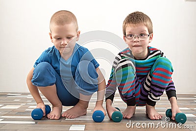 Children train with dumbbells. The concept of sport in the family Stock Photo