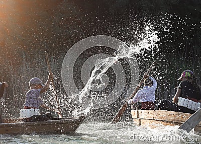 Children under the spray of water in the floating boats Editorial Stock Photo